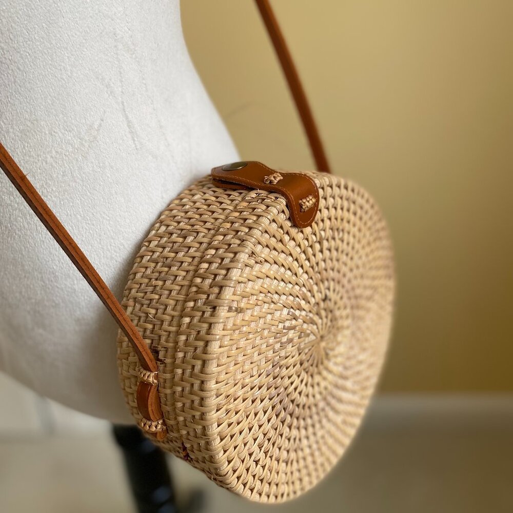 Round solid rattan woven crossbody purse cloth lined, leather accents.